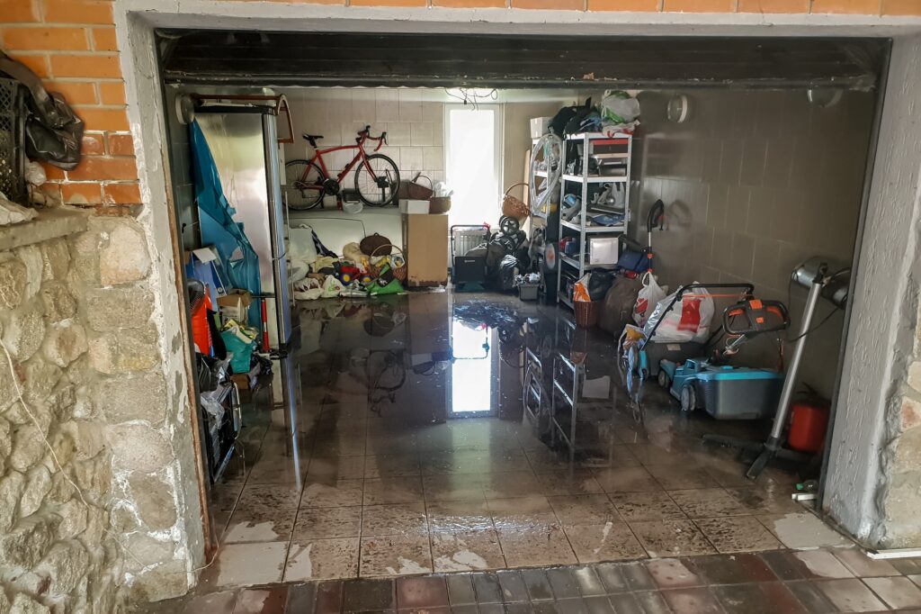 Image of flooded garage after heavy rain. Wet floor and floating thing in house after flood